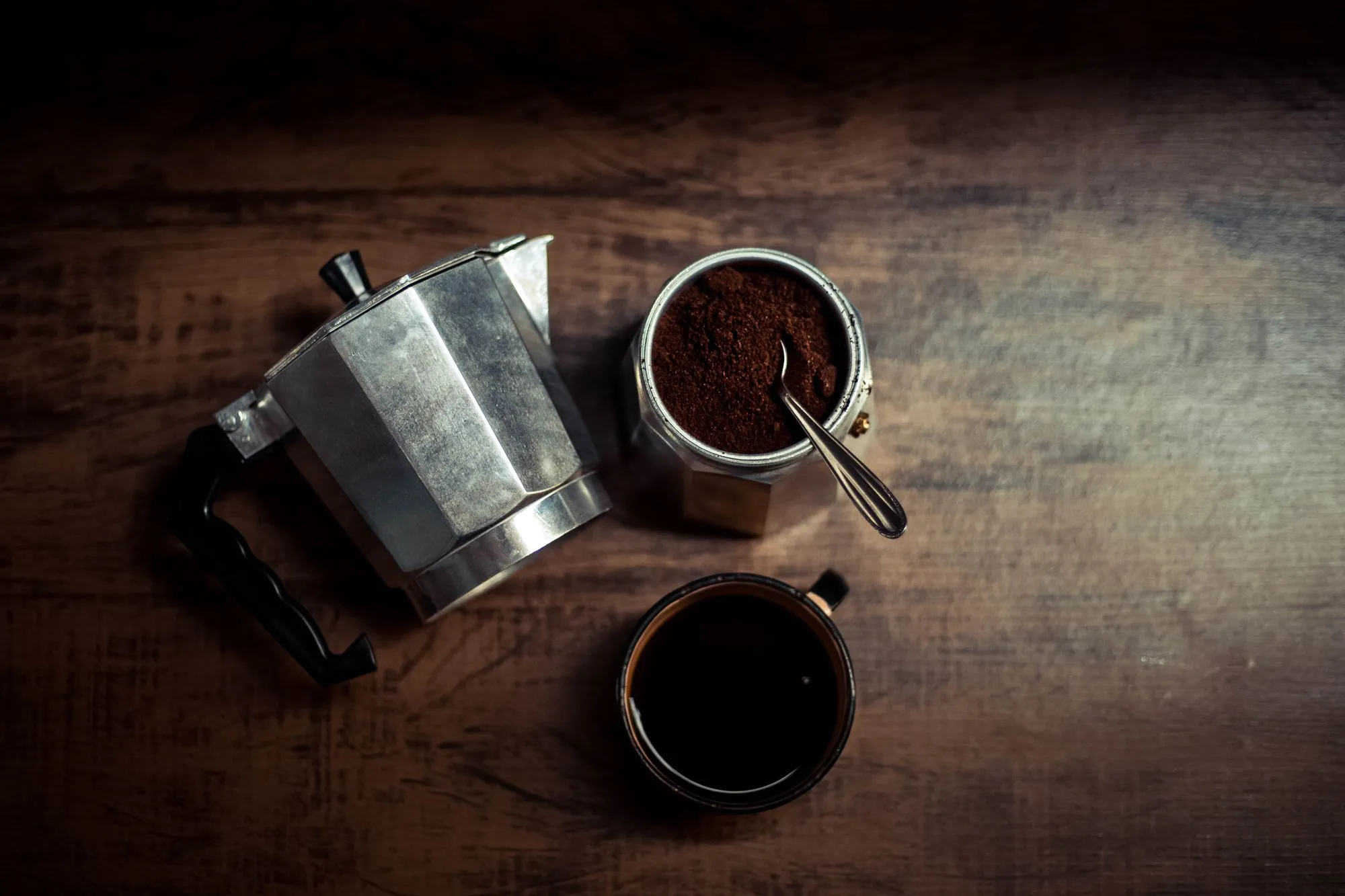 Cafetière italienne ouverte à côté d’un pot de café moulu