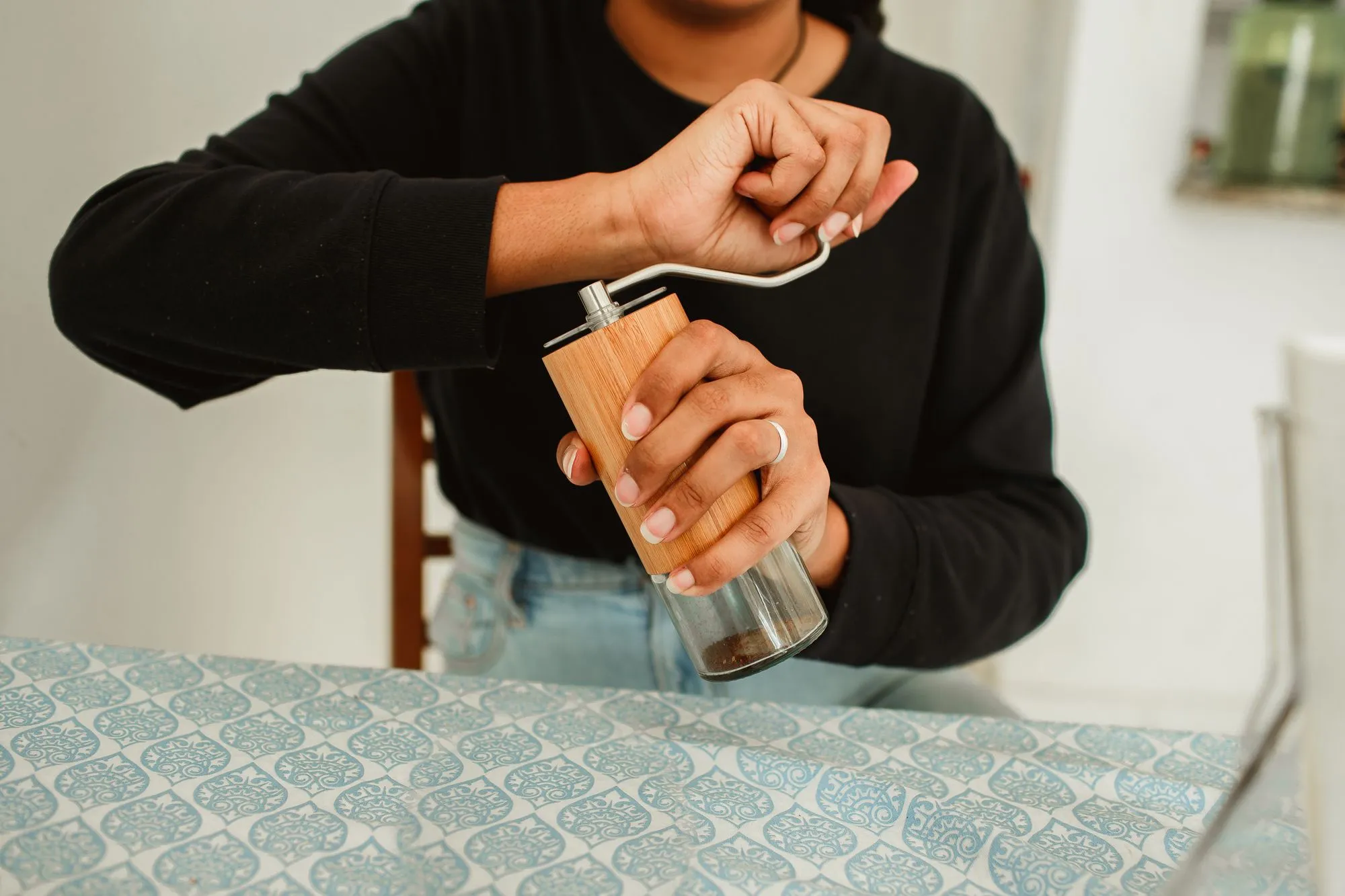 Personne qui moud son café avec un moulin manuel